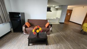 KewaneeMotel 6-Kewanee, IL的客厅配有沙发和鲜花桌