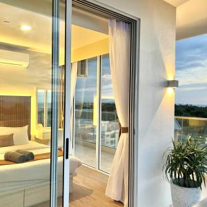 哥打京那巴鲁AruSuites Tanjung Aru Kota Kinabalu - Laxzone Suite的一间卧室享有一张床和一个阳台的美景。