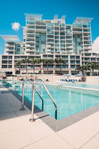 卡伦德拉Pelican Waters Golf Resort的大型公寓大楼前的游泳池