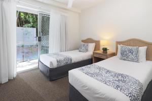 努萨角The Cove Noosa - Apartment 16的酒店客房设有两张床和窗户。