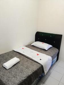 米里A&W Homestay, Vista Perdana, Miri的一间卧室设有两张单人床和白色墙壁。