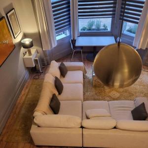 布莱顿霍夫5 Luxury Spacious Loft - Prime Location - Comfortable Bed & Sofa的客厅配有白色的沙发和桌子