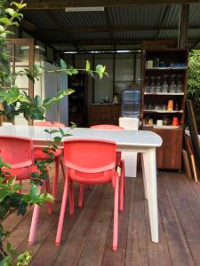 MaateaPension Te Aroha - Te Rai的庭院里设有一张白色的桌子和红色的椅子