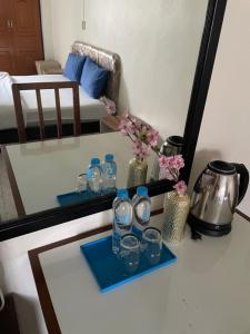 曼谷Win Mansion的桌子上装有水瓶和玻璃杯的托盘