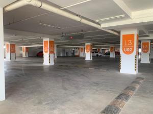芙蓉David Studio Unicity, Seremban 3的一个空的停车场,有橙色和白色的柱子
