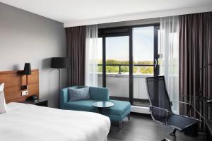 霍夫多普阿姆斯特丹机场万怡酒店的酒店的客房 - 带一张床、椅子和窗户