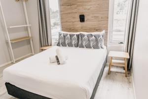 扬巴Yamba Central的卧室配有一张大白色床和窗户