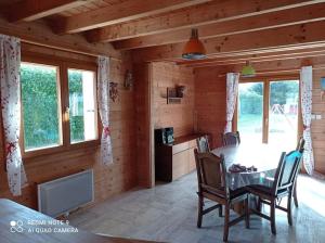 桑泰克Chalet Familial en Bois à 150 m de la Mer的小屋内带桌椅的用餐室