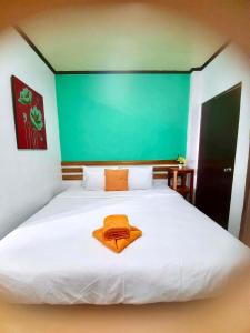 科隆科隆卡里斯景点旅馆的一张白色的大床,上面有橙色毛巾