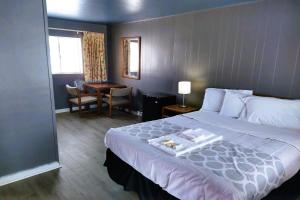 Love Hotels Desert Inn & RV at Boysen Wind River WY的酒店客房设有一张大床和一张书桌。