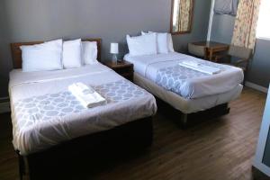 Love Hotels Desert Inn & RV at Boysen Wind River WY的酒店客房,配有两张带白色床单的床