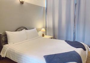 曼谷枕头和面包旅舍的卧室配有白色的床和窗户。