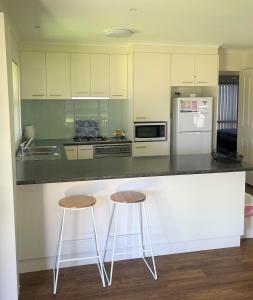 穆尔瓦拉DBJ假日公寓的厨房配有2张凳子和台面
