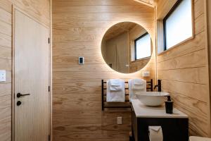 奥阿库尼Kaho - Ohakune Holiday Home with Spa的一间带水槽和镜子的浴室