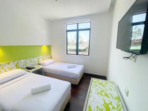 瓜埠康帕斯酒店集团兰卡威思庭酒店的客房设有两张床和一台平面电视。