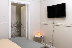 圣何塞Hotel Otoya 1907 Downtown的卧室配有一张床和壁挂式平面电视。