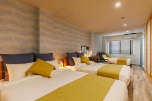 恩纳Southerlies Condominium Onna的酒店客房,设有两张黄色和白色的床