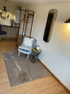 布拉克利Little Buttercup Cottage的客厅配有椅子和镜子