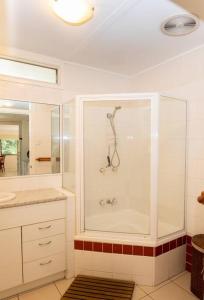 波因特卢考特Allamanda Cottage - close to beach - pet friendly的带淋浴和盥洗盆的白色浴室