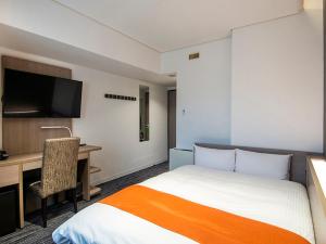 新泻新泻第一酒店的配有一张床和一张书桌的酒店客房
