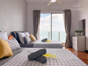 马六甲Seaview Suite SS Melaka by BetaStay的一间卧室设有两张床和大窗户