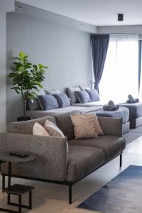 丹绒道光Deluxe Seaview Suite Twin Bed by The Only Bnb的带沙发和植物的客厅