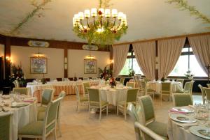 阿尔巴诺拉齐亚莱米拉蓝歌酒店的宴会厅配有桌椅和吊灯。