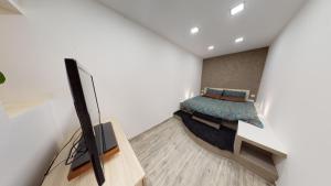 瓦莱塔Central Valletta - 1 Bedroom maisonnette的一间卧室配有一张床,并在一间客房内配有电视。