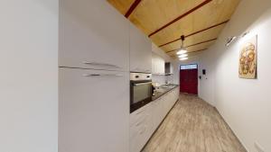 瓦莱塔Central Valletta - 1 Bedroom maisonnette的一间厨房,配有白色家电和木制天花板