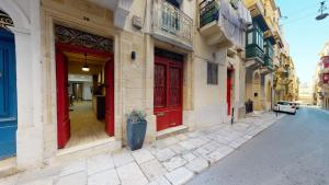 瓦莱塔Central Valletta - 1 Bedroom maisonnette的街道上一排有红色门的建筑