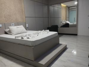 阿拉卡茹Motel FLEX LOVE LAMARAO的一间设有一张床铺的卧室,位于一个带镜子的房间