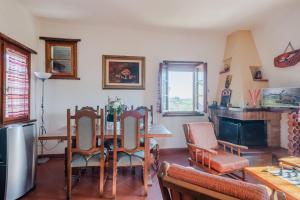 卡斯德尔诺沃贝拉登卡Chiantishire Lovely Cottage with Garden & Parking!的客厅配有桌椅和壁炉