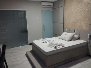 阿拉卡茹Motel FLEX LOVE LAMARAO的一间卧室,床上放着鲜花