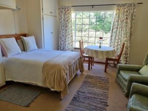 海姆维尔Yellowwood Cottage的一间卧室配有一张床、一张桌子和一个窗户。