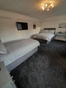 古耳riverside rooms at wheelgate house的酒店客房设有两张床和一台平面电视。