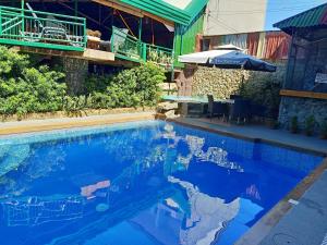 麦克坦MB花园旅馆的蓝色海水游泳池和遮阳伞