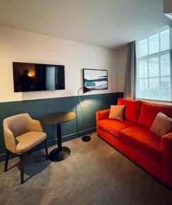 伦敦帕丁顿荣耀酒店的客厅配有红色的沙发和桌子
