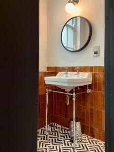 伦敦帕丁顿荣耀酒店的一间带水槽和镜子的浴室