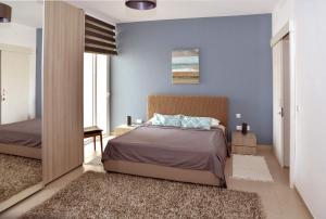 莫斯塔Valley of Honey Apartment的一间拥有蓝色墙壁、一张床和镜子的卧室