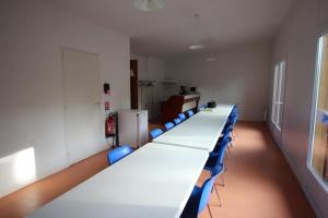 VaulryLe mas - gite n°5的一间会议室,配有长桌子和蓝色椅子