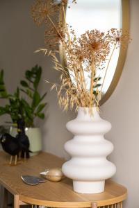 SchimmertHoeve de Binnenplaets Schimmert的一张桌子上花的白色花瓶