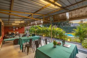 科拉德Zostel Kolad的一个带绿色桌椅的庭院和一个游泳池
