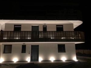 卡斯特尔罗托Villa Lara Lärche的白色的建筑,晚上设有阳台