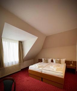 弗兰季谢克矿泉镇Lázeňský hotel Pyramida的阁楼上的卧室配有一张大床