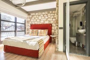 安塔利亚Delightful Flat near Hadrians Gate的一间卧室设有红色的床和石墙