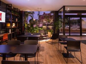 圣克鲁斯ibis Santa Cruz de la Sierra的一间设有桌椅的餐厅,享有城市美景