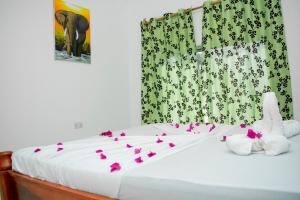 南威Daniel Zanzibar Hotel的两只填满鲜花的动物坐在床上