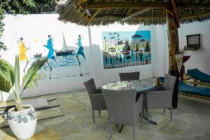 南威Daniel Zanzibar Hotel的一间带桌椅和绘画的用餐室