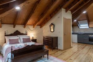 FermelãCasa dos Mortágua的一间卧室设有一张大床和木制天花板