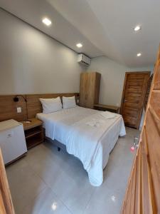 沙帕达-杜斯吉马朗伊斯Pousada e Restaurante Valle dos Ventos的卧室配有一张白色大床